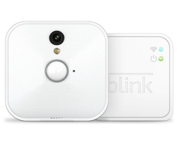 Blink wireless security camera next to its small white sync module